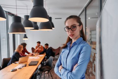 Modern ofis ortamında, sarışın bir iş kadını, stratejik tartışmalar ve karar verme sürecinde meslektaşlarıyla bir toplantı düzenler.. 