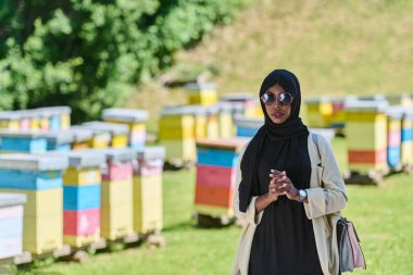 Başörtüsü içindeki Afrikalı Amerikalı Müslüman kadın bal üretimi için doğal arı çiftliklerini araştırıyor, geleneği sakin kırsal kesimde sürdürülebilirlikle harmanlıyor. 