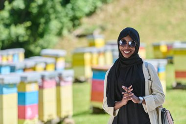 Başörtüsü içindeki Afrikalı Amerikalı Müslüman kadın bal üretimi için doğal arı çiftliklerini araştırıyor, geleneği sakin kırsal kesimde sürdürülebilirlikle harmanlıyor. 