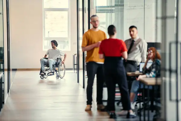 stock image A dynamic group of young entrepreneurs engages in vibrant discussion within a modern glass office space, exploring new business projects and fostering innovation.