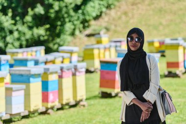 Başörtüsü içindeki Afrikalı Amerikalı Müslüman kadın bal üretimi için doğal arı çiftliklerini araştırıyor, geleneği sakin kırsal kesimde sürdürülebilirlikle harmanlıyor. 