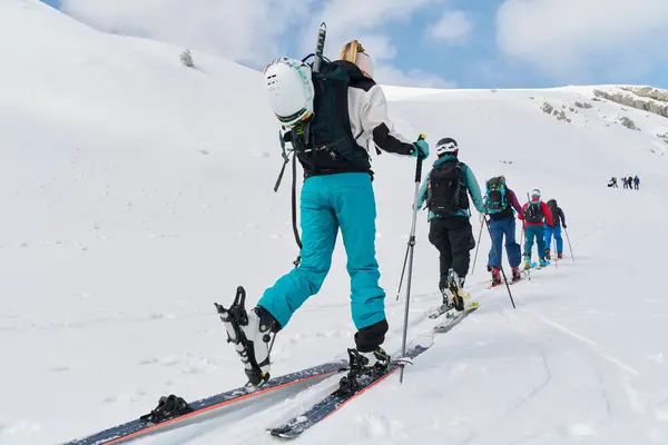 stock image A group of professional ski mountaineers ascend a dangerous snowy peak using state-of-the-art equipment. 