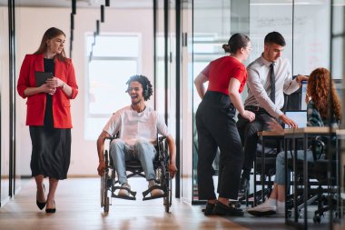 Engelli bir iş adamı olan iş arkadaşı, Afrikalı-Amerikalı bir işadamı, modern ofislerde çalışan meslektaşlarının yanından geçiyor..