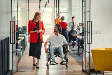 Engelli bir iş adamı olan iş arkadaşı, Afrikalı-Amerikalı bir işadamı, modern ofislerde çalışan meslektaşlarının yanından geçiyor..