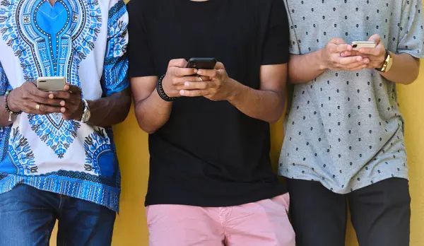 Çeşitli gençlerden oluşan bir grup, akıllı telefonlarına dalmış, modern bağlantılarını ve sosyal etkileşimlerini sergiliyorlar..