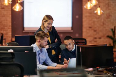 Çağdaş bir ofis ortamında, çeşitli iş adamları iş girişimlerini strateji haline getirmek ve planlamak için bilgisayarları kullanarak odaklanmış bir tartışmaya girişirler.. 