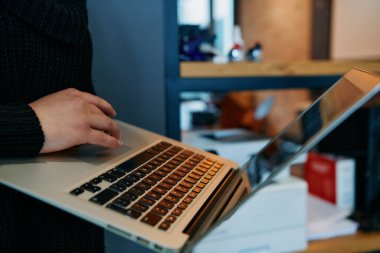 Bir ofis ortamında dizüstü bilgisayar kullanarak modern işyeri teknolojisi ve verimliliğini gösteren yakın plan bir resim..