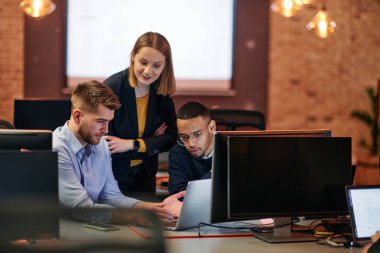 Çağdaş bir ofis ortamında, çeşitli iş adamları iş girişimlerini strateji haline getirmek ve planlamak için bilgisayarları kullanarak odaklanmış bir tartışmaya girişirler.. 