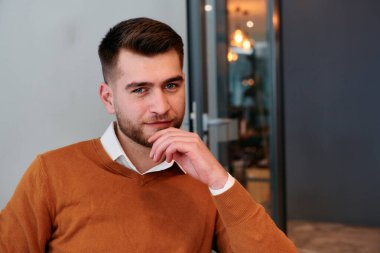 Ciddi bir iş adamı, bir ofis toplantısı sırasında masa başında otururken derin düşüncelere dalıp odaklanır ve nişan alır..