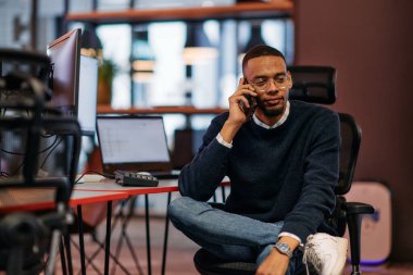 İşteki zorlu bir günden sonra, Afrikalı bir Amerikalı ofisinde teselliyi bulur, akıllı telefonunu kullanırken dinlenir ve düşünür.. 