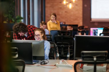 Genç Avrupalı işadamlarından oluşan bir ekip, modern ofis ortamında ortak bir proje üzerinde birlikte çalışarak bir bilgisayar üzerinde işbirliği yapıyor.