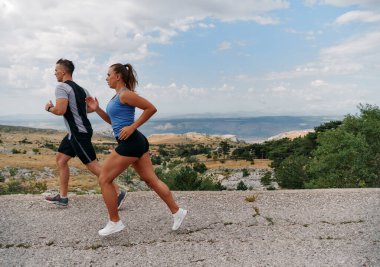  Couple conquer challenging mountain trails during an invigorating morning run. clipart