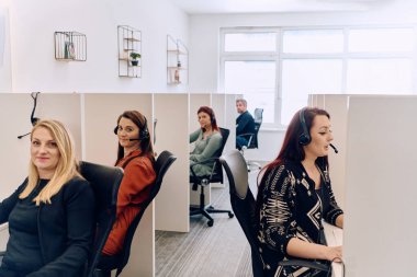 Bir çağrı merkezinde çalışan kendini adamış bir kadın ekibi, profesyonellik ve verimlilikle müşterilere telefonla yardım ve destek sağlıyor.. 