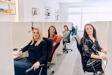 Bir çağrı merkezinde çalışan kendini adamış bir kadın ekibi, profesyonellik ve verimlilikle müşterilere telefonla yardım ve destek sağlıyor.. 