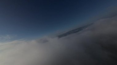 Taze bir yaz sabahı dağlarda muhteşem bir bulutlar arasında uçmak. Beyaz tüylü bulutlardan oluşan FPV insansız hava aracı açık mavi gökyüzünde usulca hareket ediyor