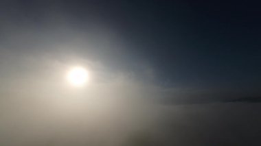 Dağlarda taze bir sabahta inanılmaz güzel bir bulutun içinden uçmak. Beyaz tüylü bulutlardan oluşan FPV insansız hava aracı açık mavi gökyüzünde usulca hareket ediyor