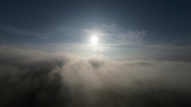 Taze bir yaz sabahı dağlarda muhteşem bir bulutlar arasında uçmak. Beyaz tüylü bulutlardan oluşan FPV insansız hava aracı açık mavi gökyüzünde usulca hareket ediyor
