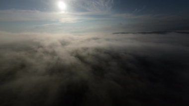 Taze bir yaz sabahı dağlarda muhteşem bir bulutlar arasında uçmak. Beyaz tüylü bulutlardan oluşan FPV insansız hava aracı açık mavi gökyüzünde usulca hareket ediyor