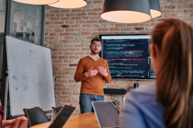 Kurumsal bir kurum kuran bir işadamı, bir toplantı düzenler, özenli ekibine tutkuyla bir iş planı sunar, işbirliği ve stratejik düşünmeyi teşvik eder.. 