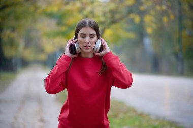 Atletik genç kadın, koşudan ve esnemeden sonra nefes alıyor ve dinleniyor. Sokakta Kadın Eğitimi ve Egzersizleri. Zayıf ve formda bir kız aktif fitness eğitiminden sonra esniyor.. 