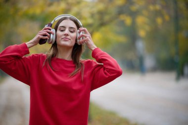 Atletik genç kadın, koşudan ve esnemeden sonra nefes alıyor ve dinleniyor. Sokakta Kadın Eğitimi ve Egzersizleri. Zayıf ve formda bir kız aktif fitness eğitiminden sonra esniyor.. 