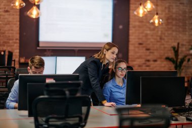 Çağdaş bir ofis ortamında, çeşitli iş adamları iş girişimlerini strateji haline getirmek ve planlamak için bilgisayarları kullanarak odaklanmış bir tartışmaya girişirler.. 