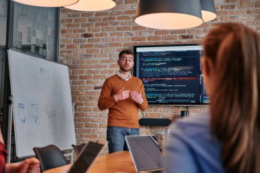 Kurumsal bir kurum kuran bir işadamı, bir toplantı düzenler, özenli ekibine tutkuyla bir iş planı sunar, işbirliği ve stratejik düşünmeyi teşvik eder.. 
