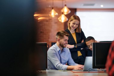 Çağdaş bir ofis ortamında, çeşitli iş adamları iş girişimlerini strateji haline getirmek ve planlamak için bilgisayarları kullanarak odaklanmış bir tartışmaya girişirler.. 