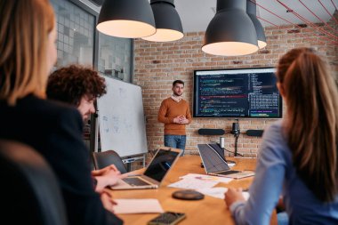 Kurumsal bir kurum kuran bir işadamı, bir toplantı düzenler, özenli ekibine tutkuyla bir iş planı sunar, işbirliği ve stratejik düşünmeyi teşvik eder.. 