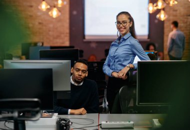 Çağdaş bir ofis ortamında, sarışın bir iş kadını ve onun Afrikalı Amerikalı iş ortağı, internetteki belgelere odaklanmış bir kararlılıkla bakıyorlar.