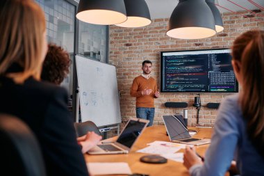 Kurumsal bir kurum kuran bir işadamı, bir toplantı düzenler, özenli ekibine tutkuyla bir iş planı sunar, işbirliği ve stratejik düşünmeyi teşvik eder.. 