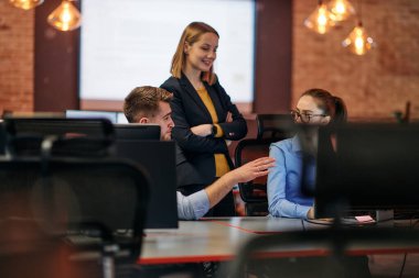 Çağdaş bir ofis ortamında, çeşitli iş adamları iş girişimlerini strateji haline getirmek ve planlamak için bilgisayarları kullanarak odaklanmış bir tartışmaya girişirler.. 