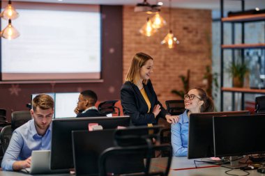 Çağdaş bir ofis ortamında, çeşitli iş adamları iş girişimlerini strateji haline getirmek ve planlamak için bilgisayarları kullanarak odaklanmış bir tartışmaya girişirler.. 