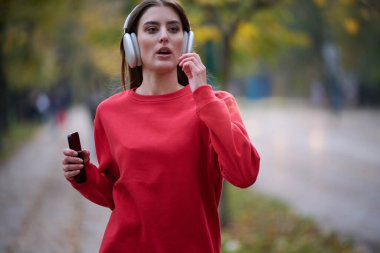 Atletik genç kadın, koşudan ve esnemeden sonra nefes alıyor ve dinleniyor. Sokakta Kadın Eğitimi ve Egzersizleri. Zayıf ve formda bir kız aktif fitness eğitiminden sonra esniyor.. 