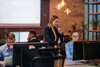 Çağdaş bir ofis ortamında, çeşitli iş adamları iş girişimlerini strateji haline getirmek ve planlamak için bilgisayarları kullanarak odaklanmış bir tartışmaya girişirler.. 