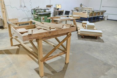 CNC kesme makinelerinin ve çeşitli ahşap işleme ekipmanlarının sergilendiği bir ahşap işleme tesisinin iç görünümü.