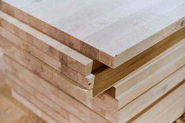 Çeşitli ahşap parçalar ve tahtalar CNC ahşap makinelerinde daha fazla işlem için hazırlanan bir depoda düzenli olarak depolanır..