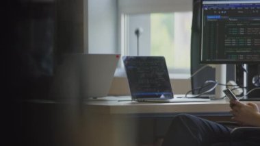 Modern bir iş kadını, mesai saatleri boyunca akıllı telefonunu kullanarak çağdaş bir ofiste mola verir.