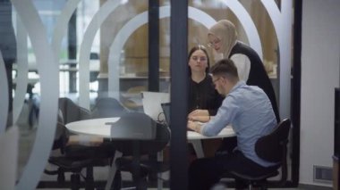  Çeşitli meslekdaşlardan oluşan bir grup, takım çalışması, üretkenlik ve dinamik bir şirket ortamını örnek alarak, modern bir ofiste çeşitli iş görevlerini birlikte ve verimli bir şekilde yerine getiriyor.