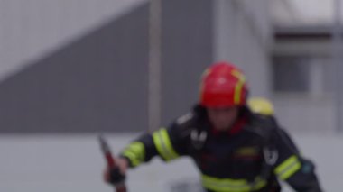İtfaiyecilerden oluşan özel bir ekip bir itfaiye aracından hortumları alıyor ve tehlikeli bir tehlikeyle mücadele etmedeki cesaret ve profesyonel uzmanlıklarını sergileyerek, yanan bir yangını söndürmek için tehlikeli bir göreve çıkıyorlar.