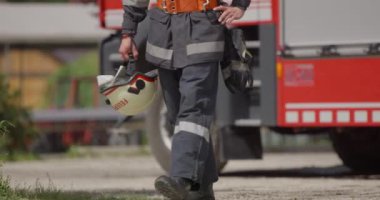 İtfaiye arabasının yanında duran özel bir itfaiye eri tehlikeli yangın senaryolarında yüksek riskli bir kurtarma görevine hazırlanıyor. Acil durumlarda hayat kurtarmaya kararlı olduğunu gösteriyor.
