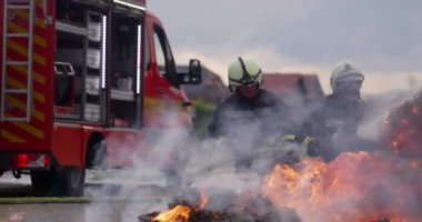 İtfaiyeciler yangını kontrol etmek için alevlerle savaşır, yayılmak için değil. İtfaiyeci endüstriyel ve kamu güvenliği kavramı. Trafik ya da araba kazası kurtarma ve eyleme yardım. Yüksek kalite fotoğraf