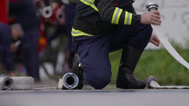 İtfaiyecilerden oluşan özel bir ekip bir itfaiye aracından hortumları alıyor ve tehlikeli bir tehlikeyle mücadele etmedeki cesaret ve profesyonel uzmanlıklarını sergileyerek, yanan bir yangını söndürmek için tehlikeli bir göreve çıkıyorlar.