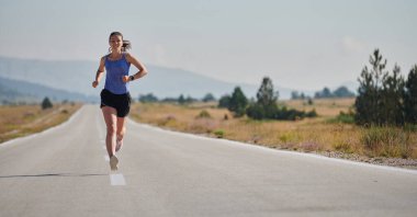 Atletik bir kadın sağlıklı bir yaşam tarzında özgürlük ve neşe bulur. Gün doğumunda güzel bir patikada koşar.. 