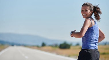 An athletic woman finds freedom and joy in a healthy lifestyle, running through a beautiful road trail at sunrise.  clipart