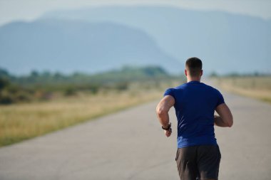Atletik bir adam koşarken kararlılığını sergiler, sağlıklı bir yaşam tarzına ve yaklaşan maraton yarışmasına hazırlanmaya bağlıdır.