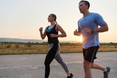 A vibrant couple dashes running the outdoors, embodying the essence of athleticism and romance, their confident strides reflecting a shared commitment to fitness and preparation for future marathon clipart