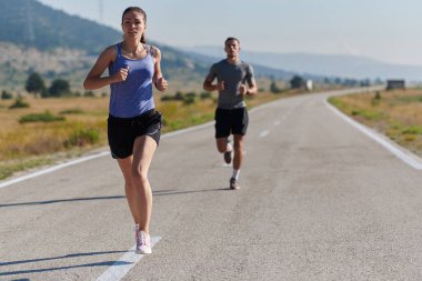 Bir çift güneş lekeli bir yolda koşar, vücutları güçlü ve sağlıklıdır, birbirlerine olan sevgileri ve her adımda aşikardır.. 