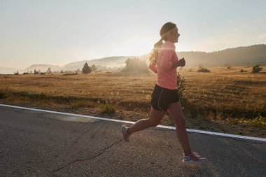 Kararlı ve motive olmuş bir sporcu gün doğumuna güvenle koşuyor, sabah koşusunda kararlılığını ve gücünü özetliyor.. 