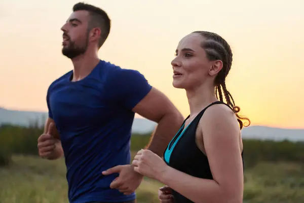 stock image A vibrant couple dashes running the outdoors, embodying the essence of athleticism and romance, their confident strides reflecting a shared commitment to fitness and preparation for future marathon